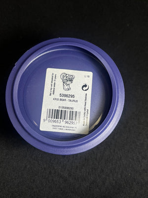 Purple container lid with a label on a black background