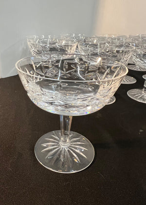 Set of crystal champagne coupes on a dark surface