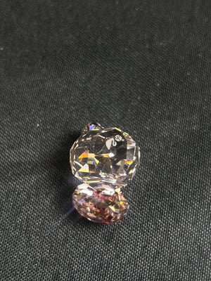 Two crystal beads on a dark fabric background