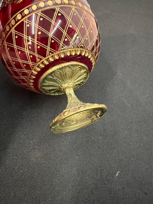 Decorative red and gold egg on a dark fabric background
