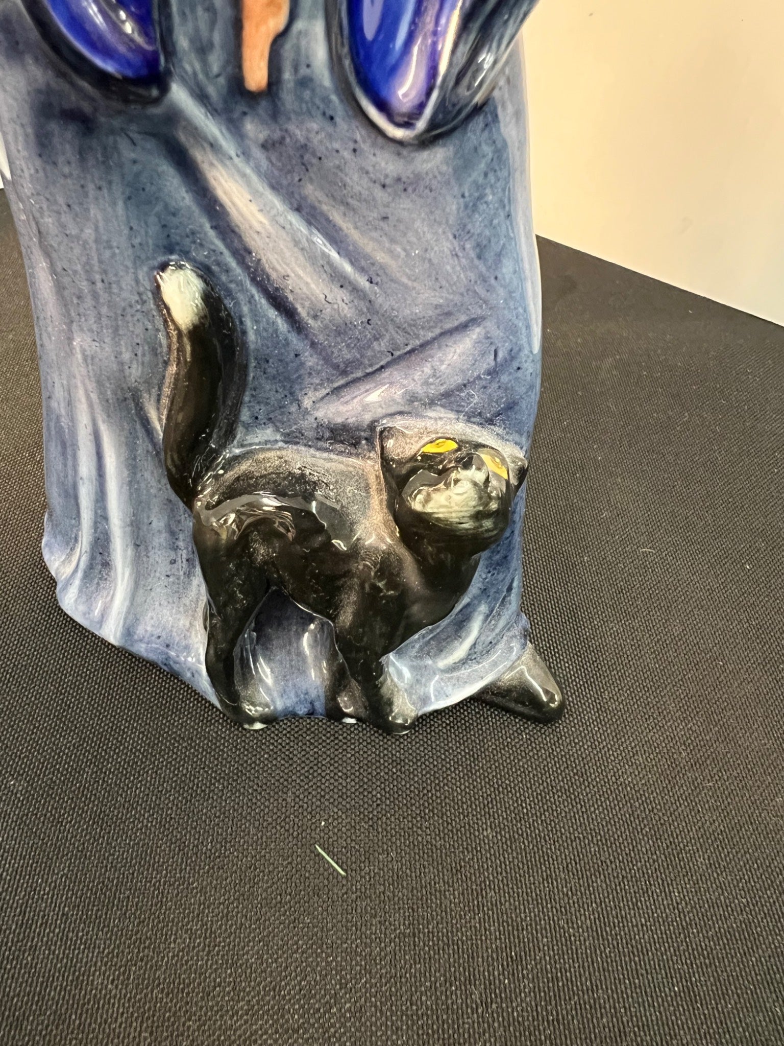 Ceramic vase with a face design on a black surface