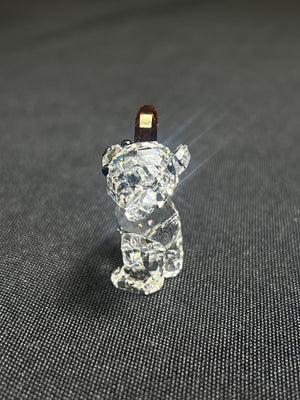 Clear crystal bear figurine on a dark textured surface