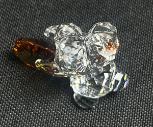 Clear crystal flower-shaped object on a textured black surface