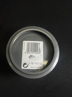 Metallic can lid with a barcode label on a black background