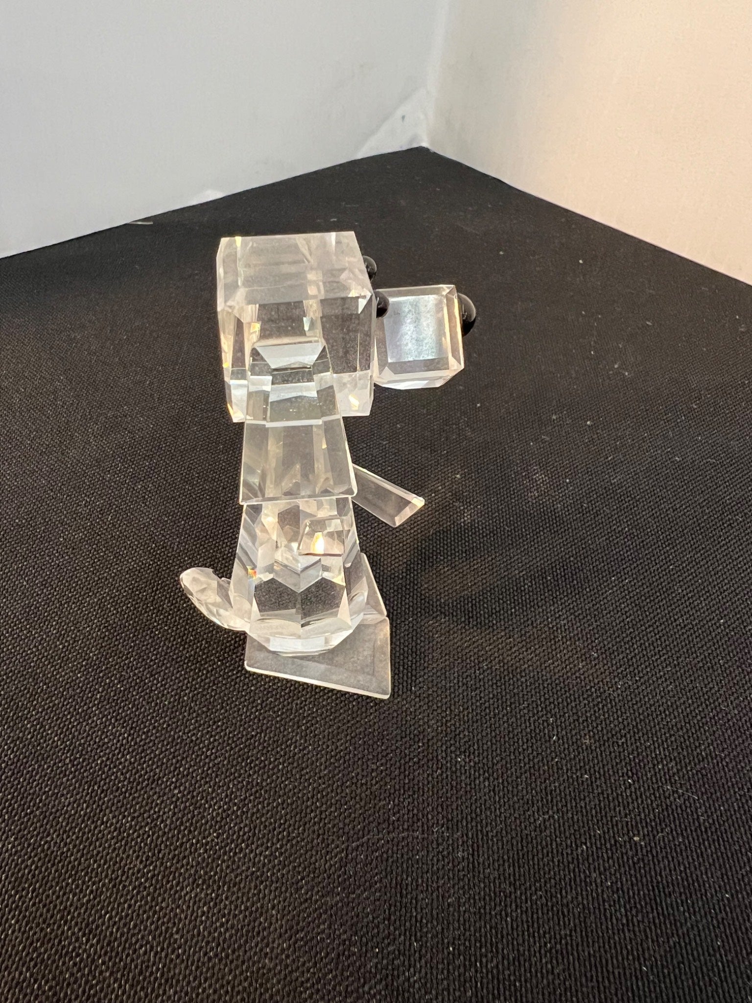 Clear plastic robot figure on a black surface