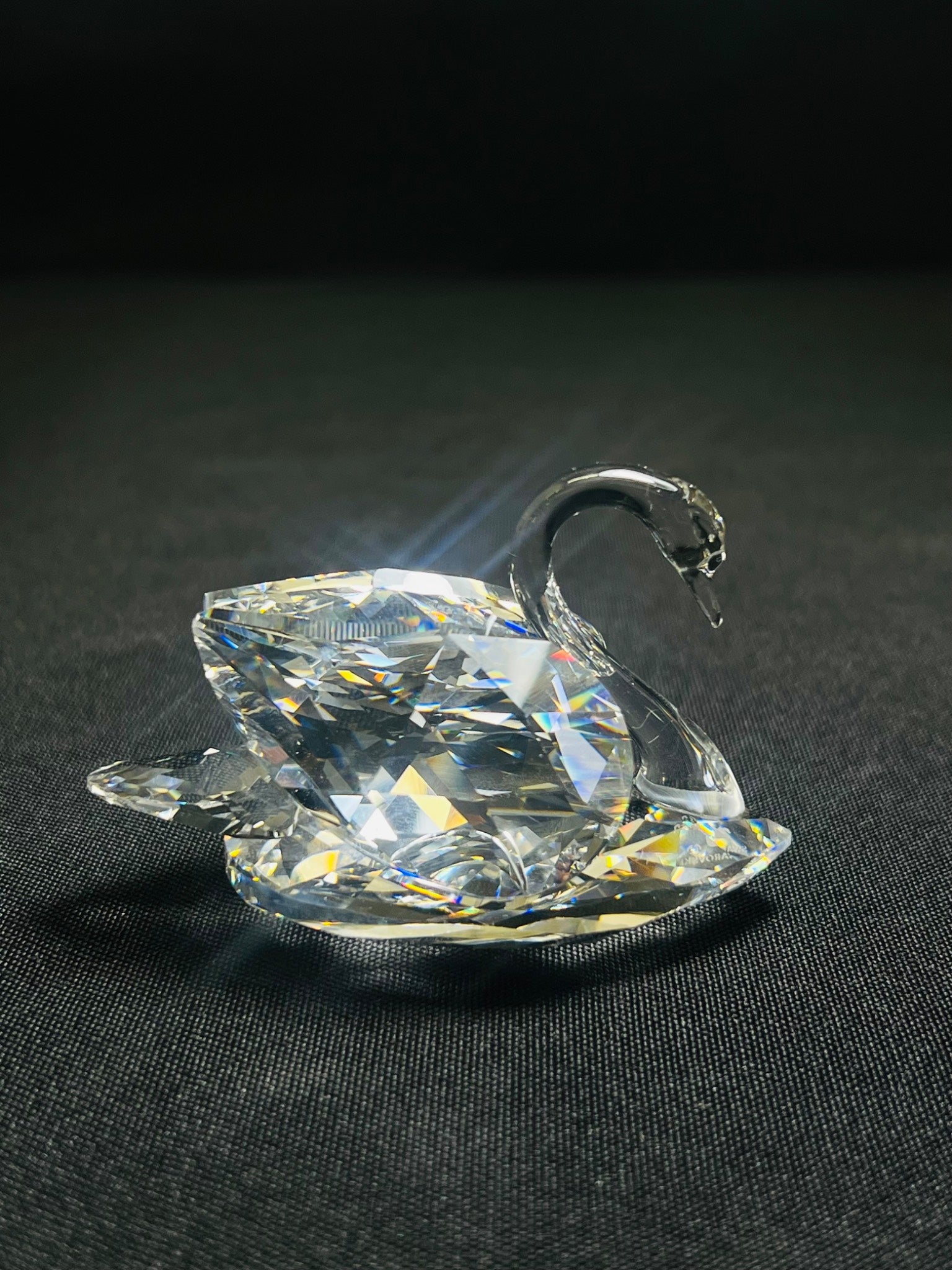 Crystal swan figurine on a black background