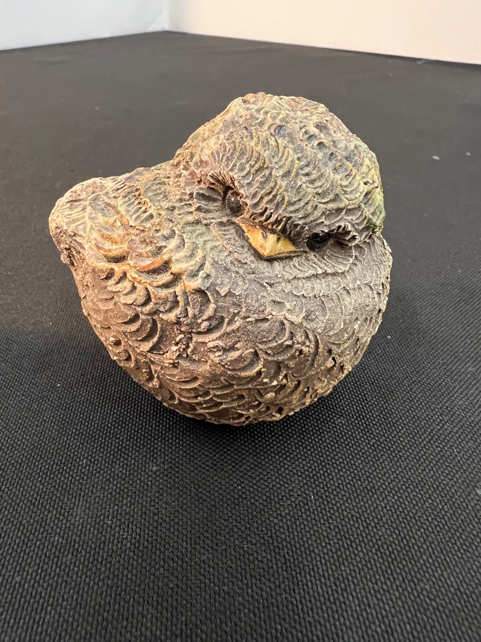 Decorative stone bird sculpture on a black surface