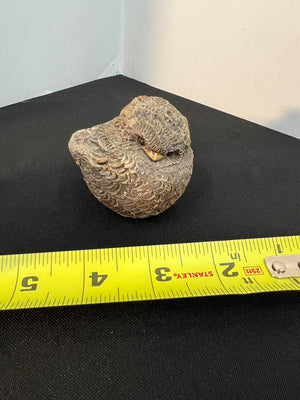 Rock on a black surface with a yellow measuring tape