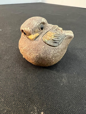 Stone sculpture of a bird on a black surface