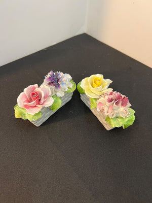 Two decorative flower boxes on a black surface with a white background