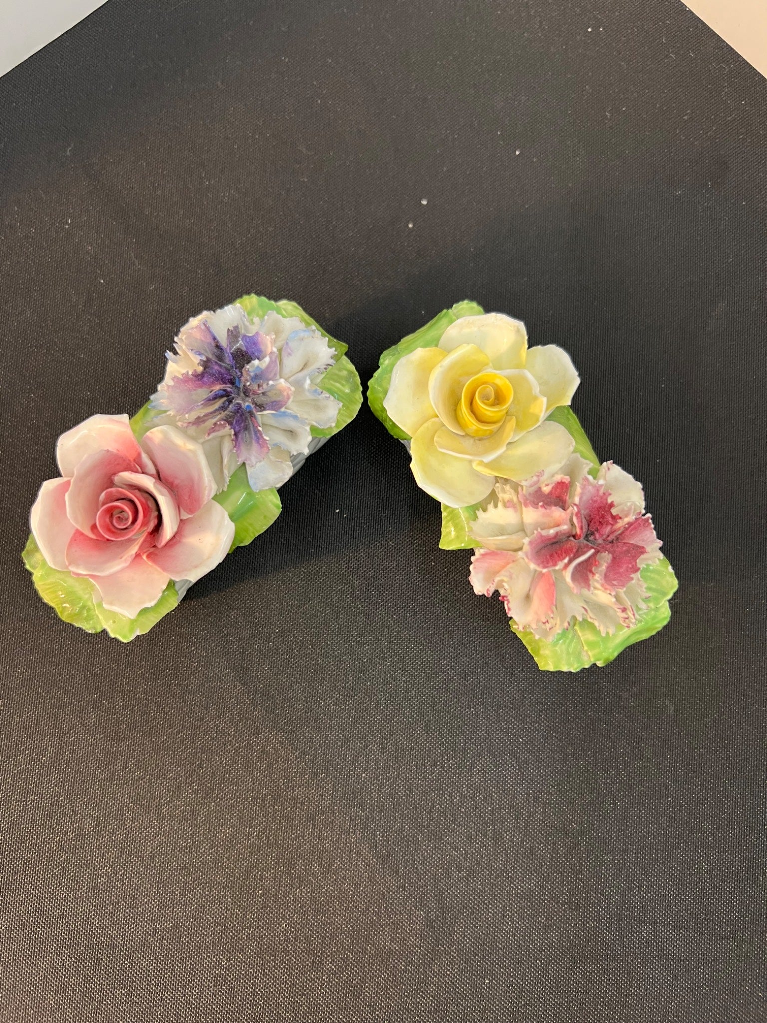 Two floral hair clips on a black background