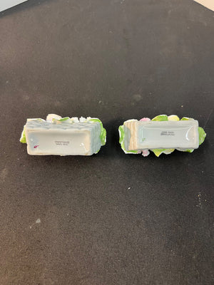 Two decorative items with green bases on a black surface