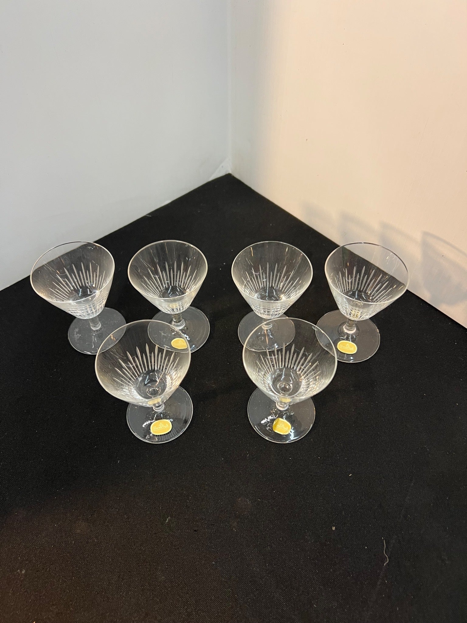 Set of six clear glass cocktail glasses on a black surface with a white background