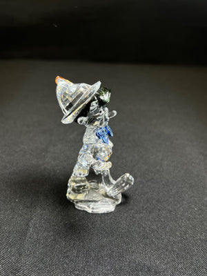 Crystal figurine of a dog with a hat on a dark background