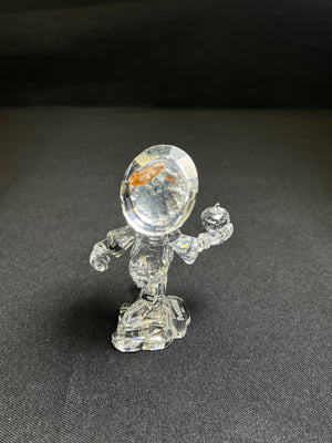 Clear glass figurine on a dark gray background