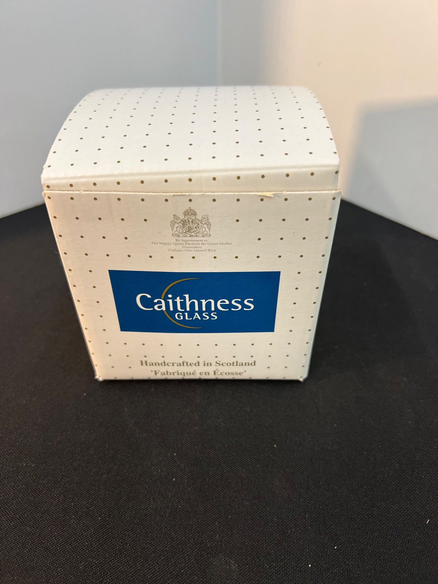 Caithness Glass box with blue logo on a black surface