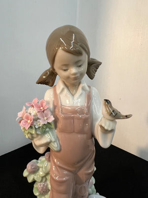 Porcelain figurine of a girl holding flowers and a bird