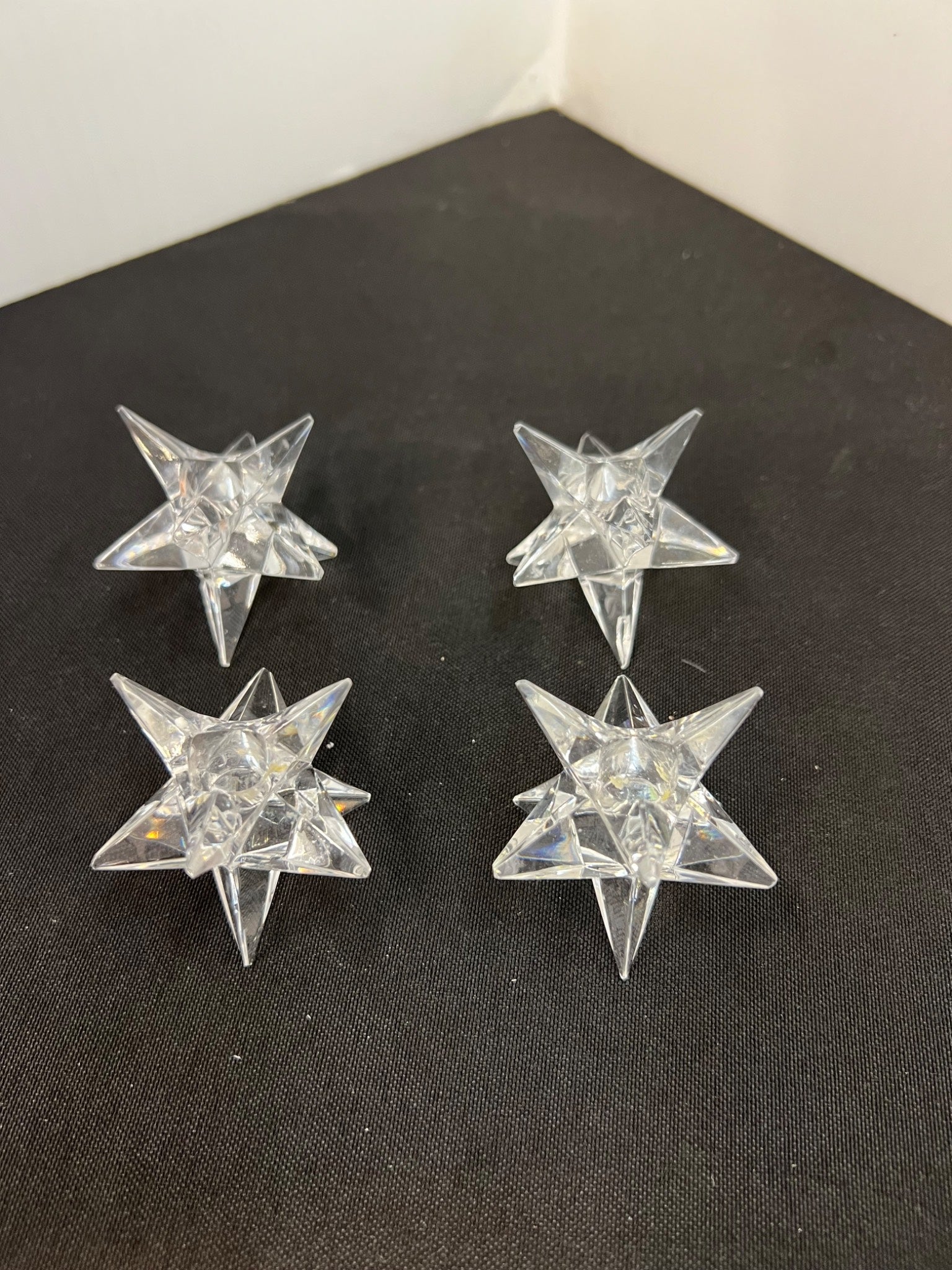 Four clear star-shaped objects on a black surface