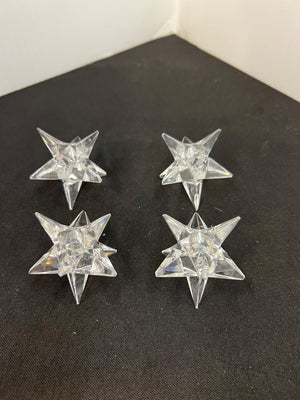 Four clear star-shaped objects on a black surface