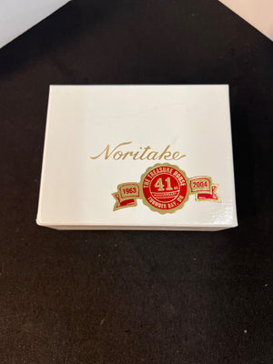 Noritake box with gold and red branding on a dark background