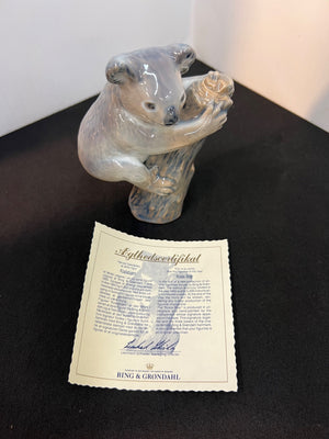 Glass bear figurine with a certificate on a dark surface