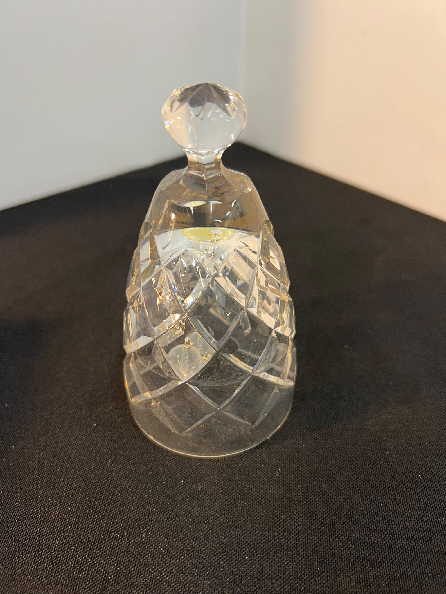 Clear glass bell-shaped object on a dark surface