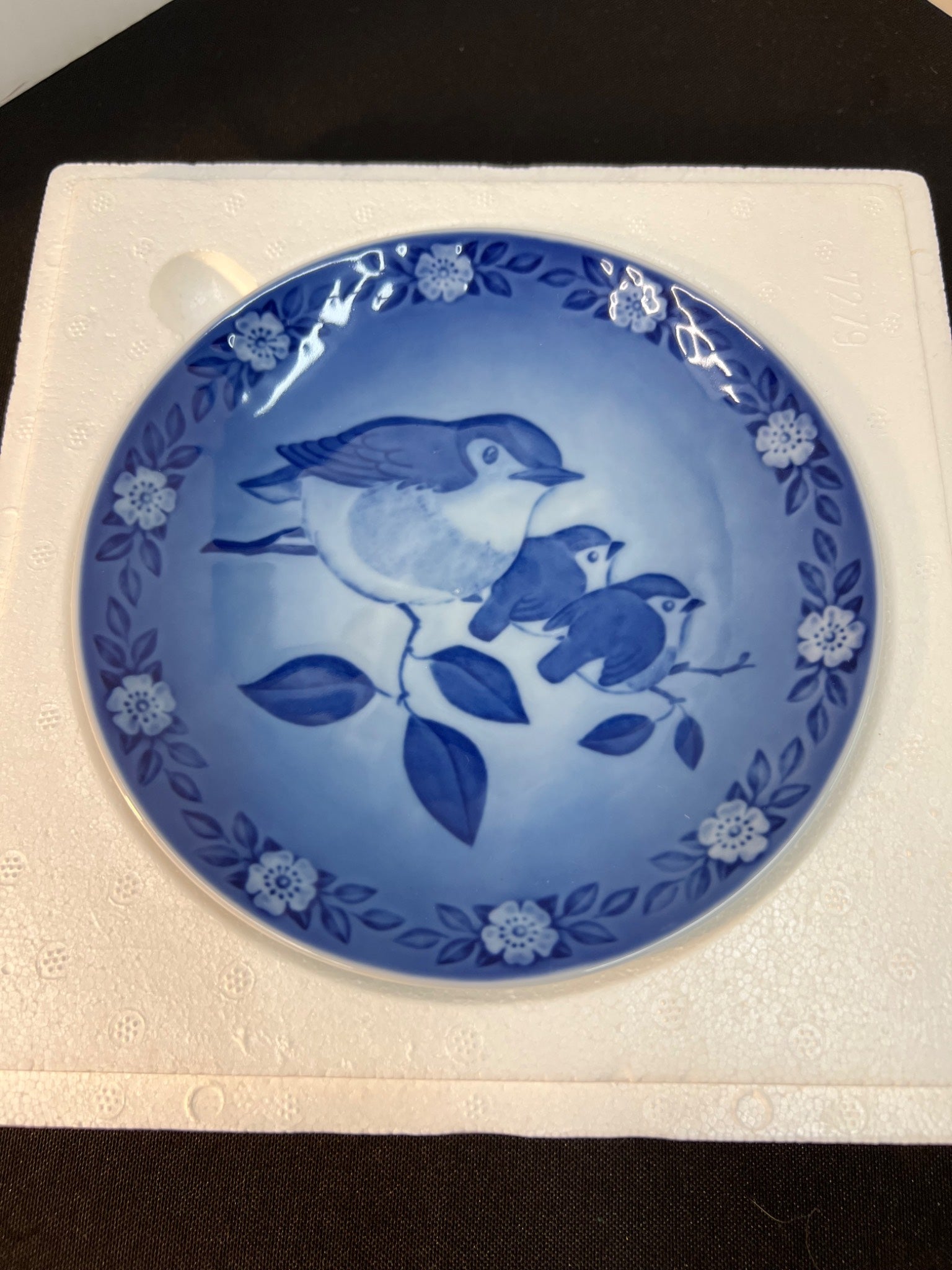 Blue ceramic plate with bird design on a white background