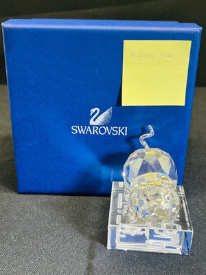 Swarovski crystal figurine on a stand with a blue Swarovski box in the background.