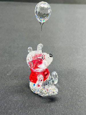 Crystal bear figurine with a red base and clear balloon on a gray background