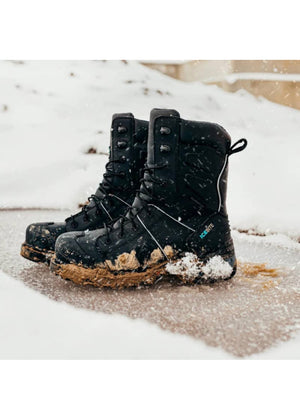 Pair of black winter boots with brown soles on a snowy ground