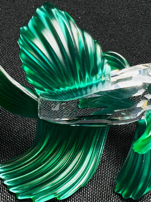 Green and clear glass sculpture on a black background