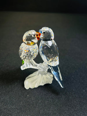 Crystal figurine of two birds on a black background