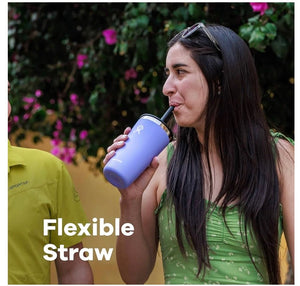 Woman drinking from a purple tumbler with a flexible straw outdoors.