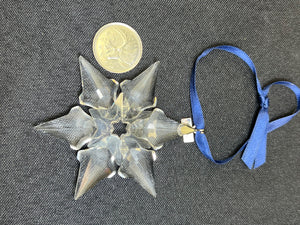 Decorative star-shaped object with a blue ribbon on a textured gray background