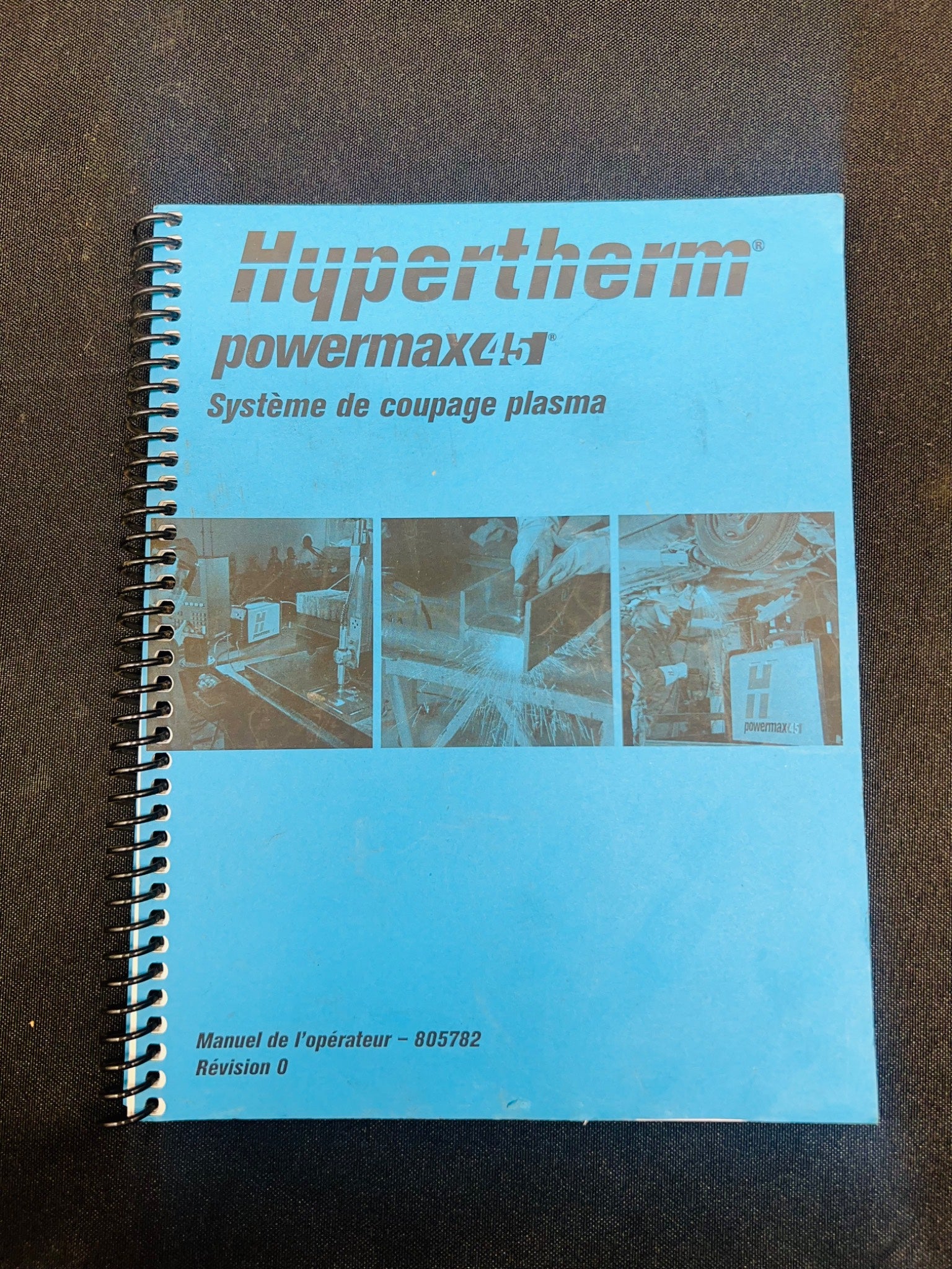 Blue manual with Hypertherm branding on a brown surface