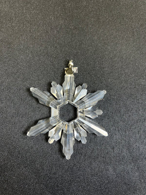 Crystal snowflake ornament on a dark background