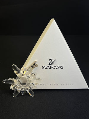 Swarovski crystal ornament on a branded Swarovski stand against a black background
