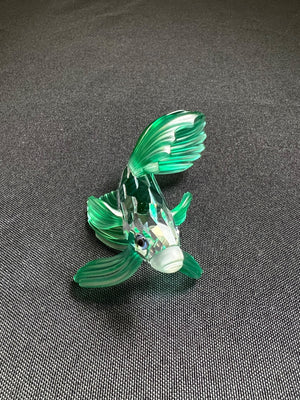 Glass fish figurine on a gray surface