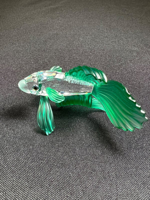 Glass fish figurine on a gray background