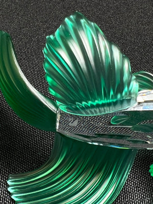 Clear green glass sculpture on a black textured background