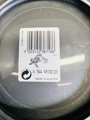 Close-up of a barcode label on a black surface with text and symbols.
