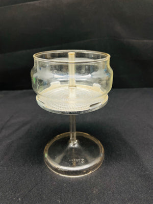 Clear glass object with a stand on a black background