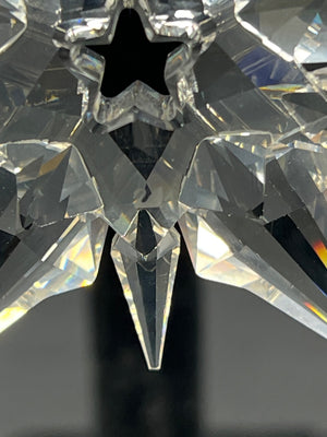 Close-up of a crystal object with star-like design on a dark background