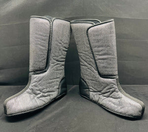 Pair of gray quilted knee-high boots on a gray background