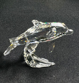 Crystal dolphin figurine on a black background