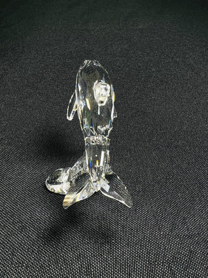 Clear glass figurine of a dog on a black background