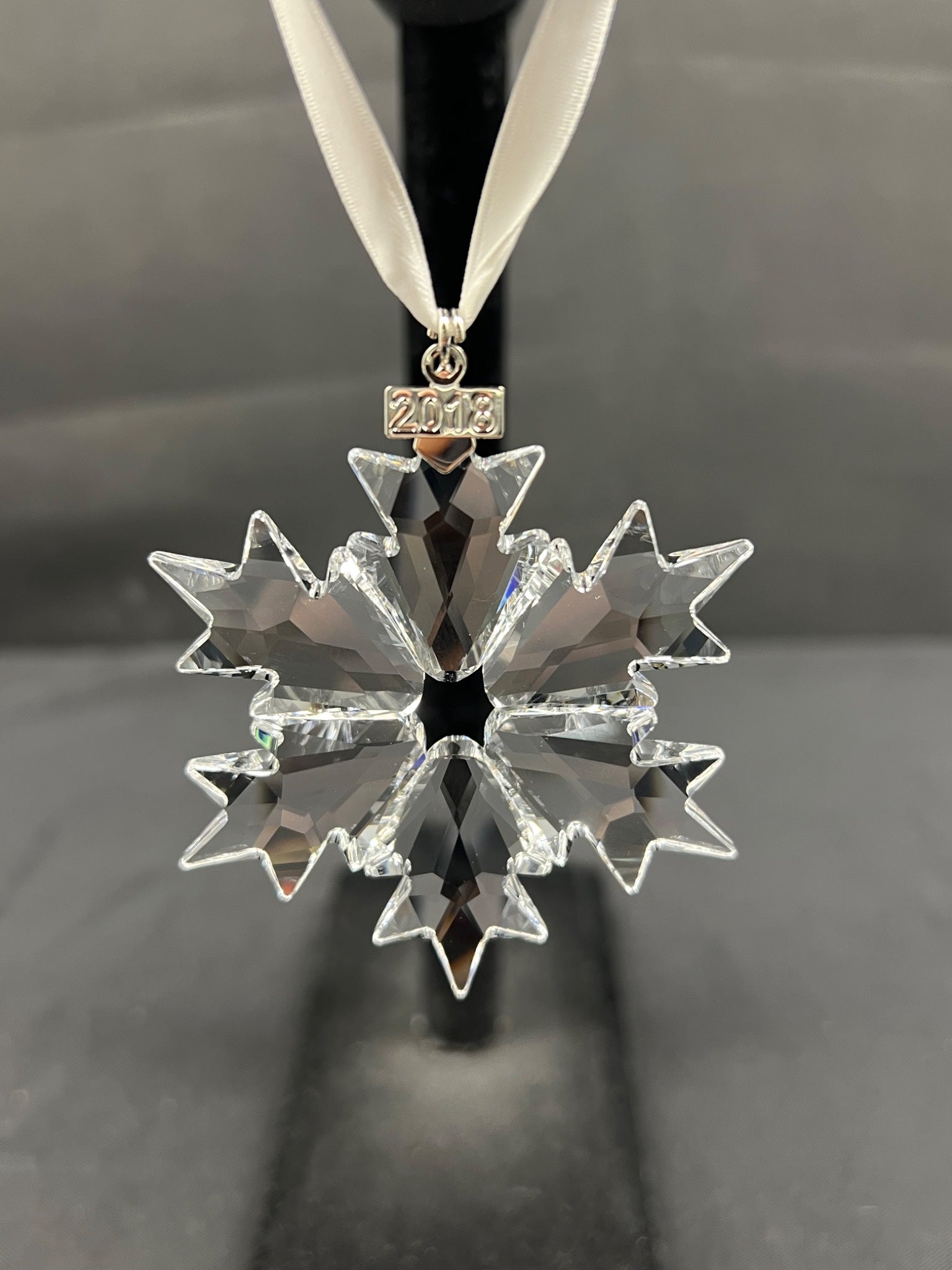 Crystal snowflake ornament with '2018' on a black background