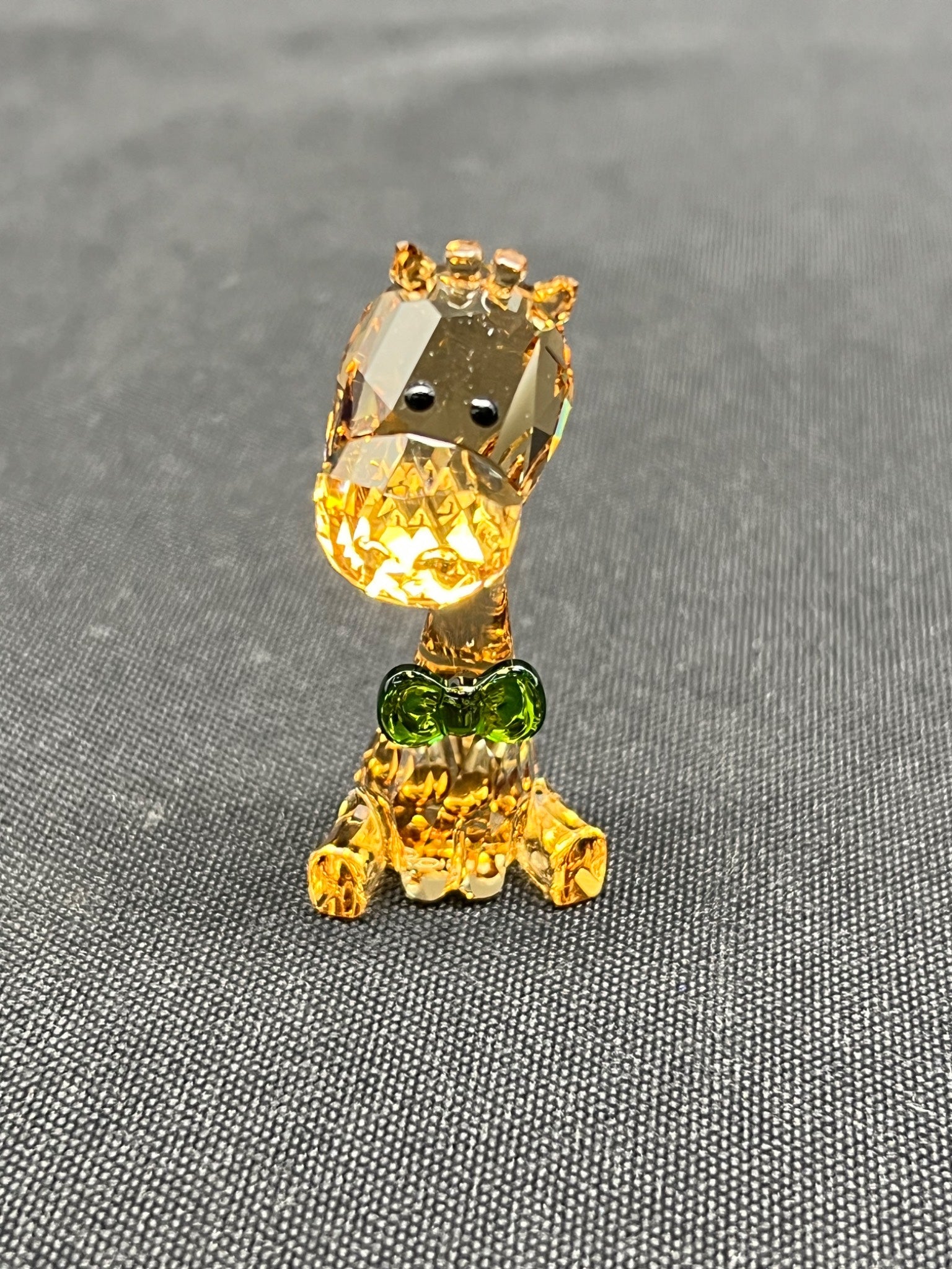 Crystal figurine of a character on a gray textured background