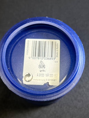 Close-up of a blue container lid with a barcode label on a dark background