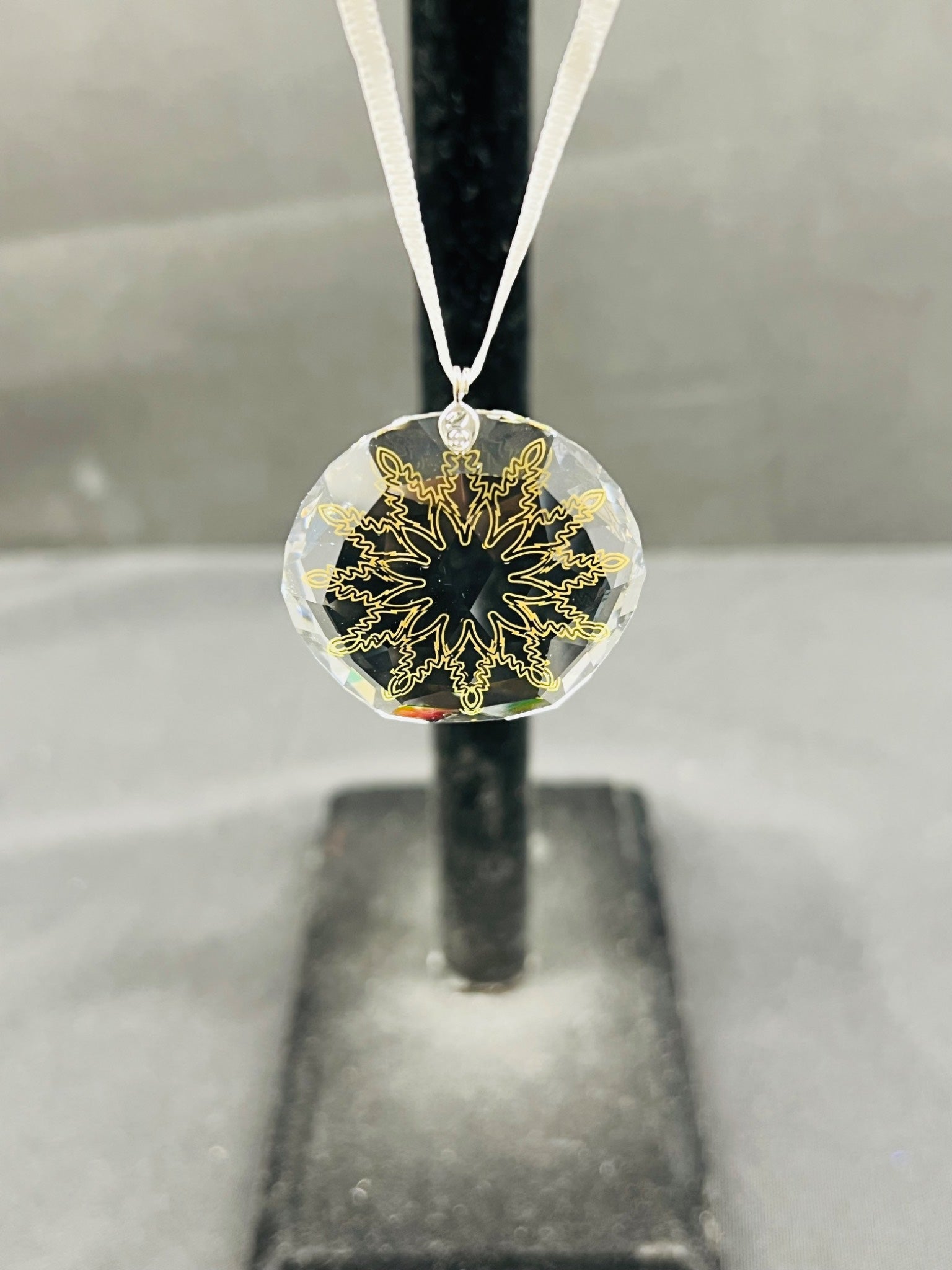 Decorative pendant with gold intricate design on a clear background